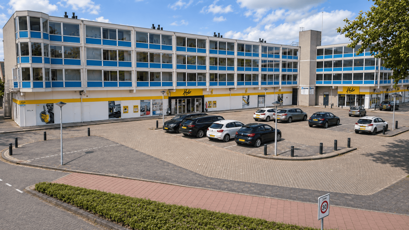 Hubo Spijkenisse – gevel en parkeerplaats Gevel van Hubo Spijkenisse met parkeerplaatsen aan de Oberonweg
